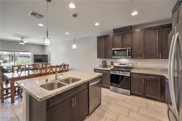 kitchen with sink, appliances with stainless steel finishes, dark brown cabinets, a kitchen island with sink, and ceiling fan