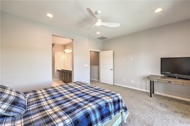 bedroom featuring ceiling fan, connected bathroom, and light carpet