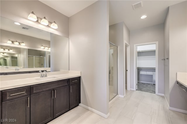 bathroom with tile patterned flooring, an enclosed shower, and vanity