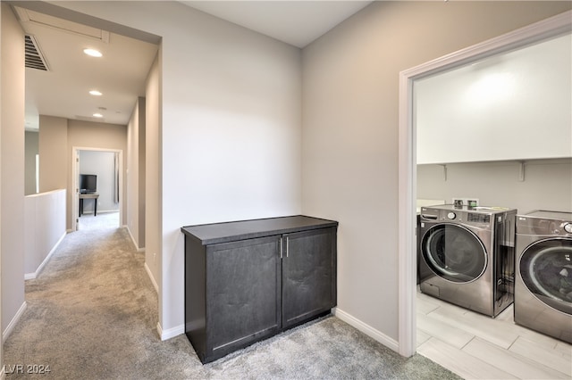 laundry area with washing machine and clothes dryer and light colored carpet