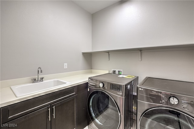 clothes washing area with separate washer and dryer, sink, and cabinets