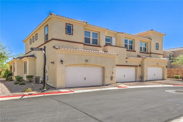 mediterranean / spanish-style house with central AC and a garage