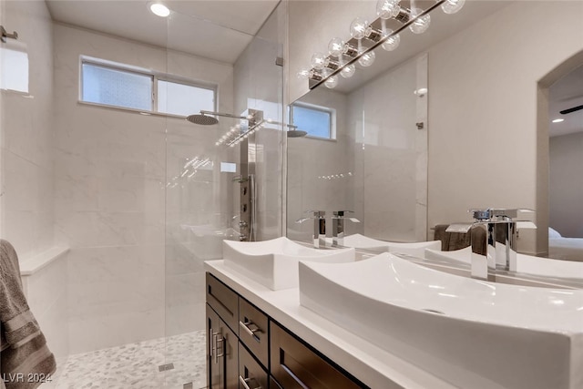 bathroom featuring a sink, double vanity, and walk in shower