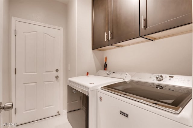 washroom featuring cabinet space and washing machine and clothes dryer