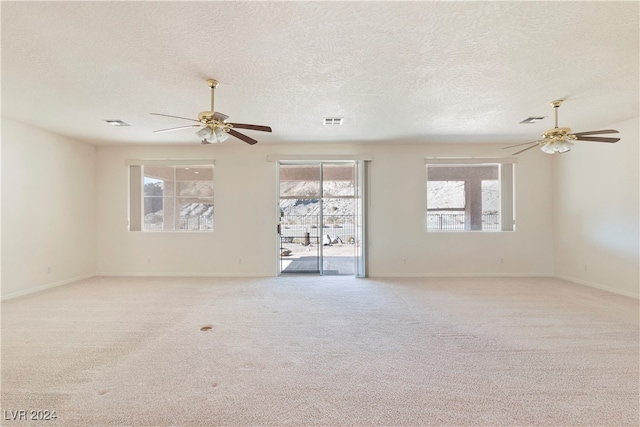 carpeted spare room with a textured ceiling and ceiling fan