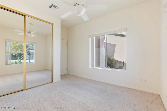 unfurnished bedroom with a closet, ceiling fan, and light colored carpet