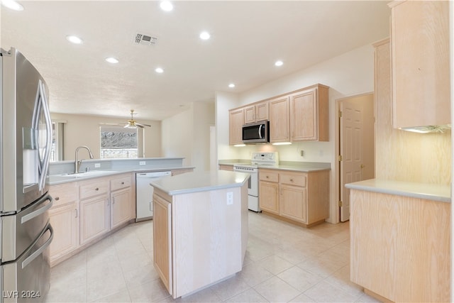 kitchen featuring kitchen peninsula, stainless steel appliances, light brown cabinetry, and a kitchen island