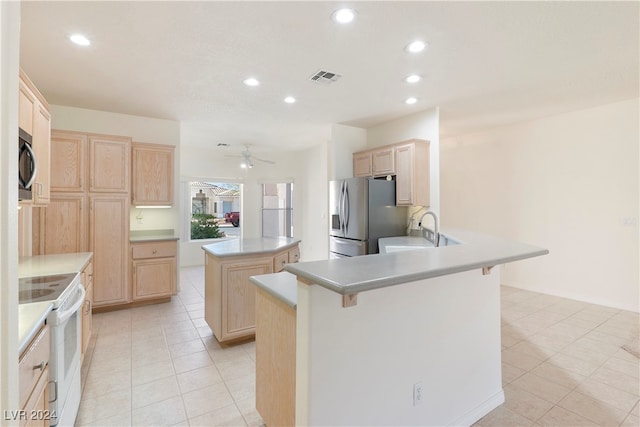 kitchen featuring ceiling fan, light brown cabinets, kitchen peninsula, and stainless steel appliances