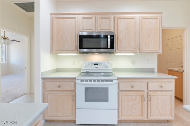 kitchen with light colored carpet, light brown cabinets, and electric range