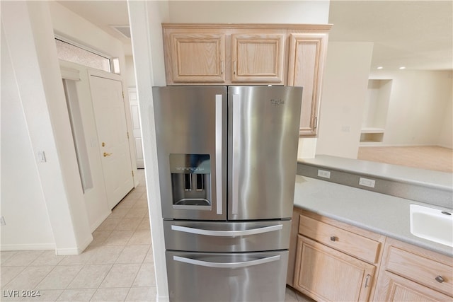 kitchen with light tile patterned flooring, light brown cabinets, and stainless steel refrigerator with ice dispenser