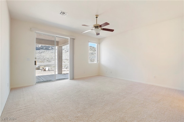 empty room featuring ceiling fan and light colored carpet