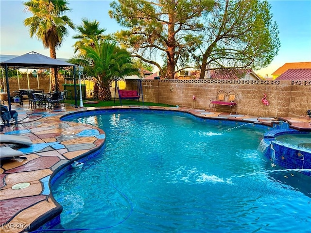 view of pool with a gazebo, a fenced backyard, a pool with connected hot tub, and a patio