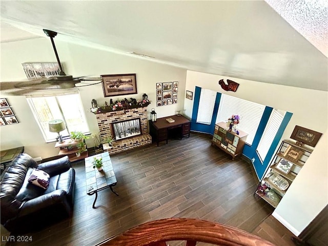 living room with vaulted ceiling, dark wood-style floors, and a fireplace