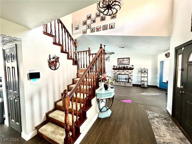 stairs featuring a brick fireplace, wood finished floors, and baseboards