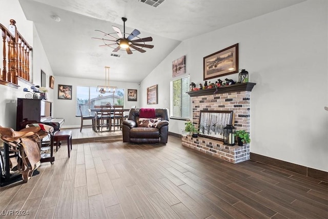 living room with visible vents, ceiling fan, lofted ceiling, a fireplace, and wood finished floors