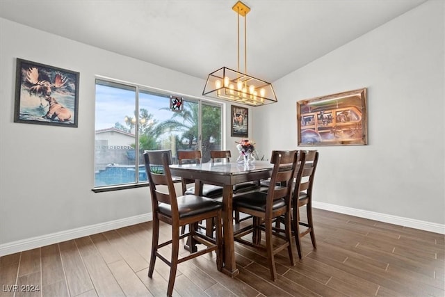 dining area with baseboards, an inviting chandelier, and wood tiled floor