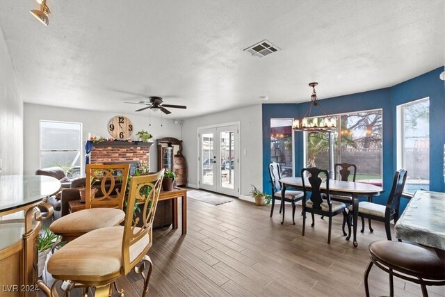 dining room with visible vents, plenty of natural light, french doors, and light wood-type flooring