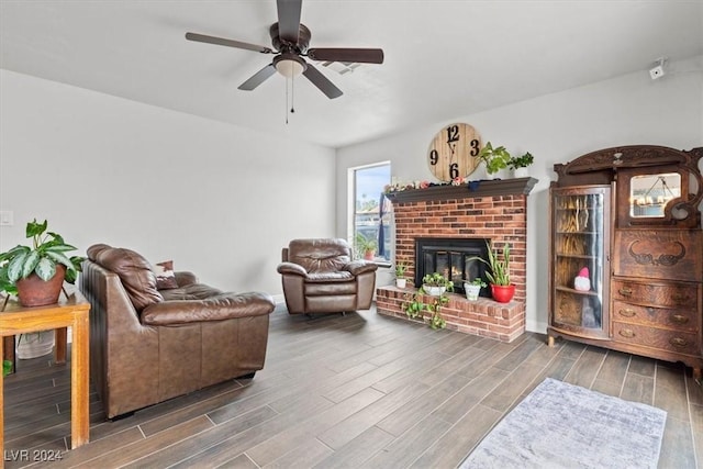 living area with a ceiling fan, a fireplace, and wood finish floors