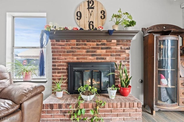 interior details featuring a brick fireplace and wood finished floors