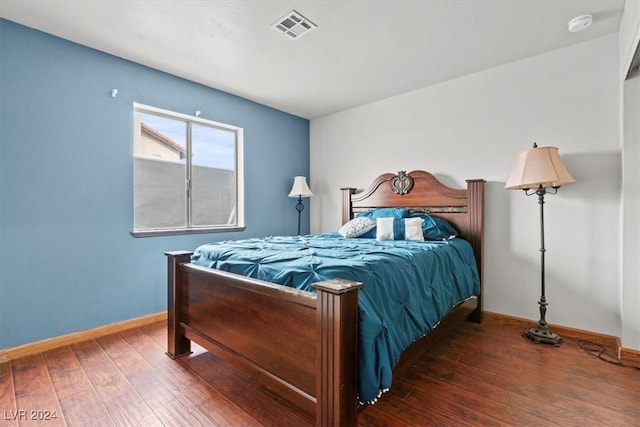 bedroom featuring baseboards, visible vents, and wood-type flooring