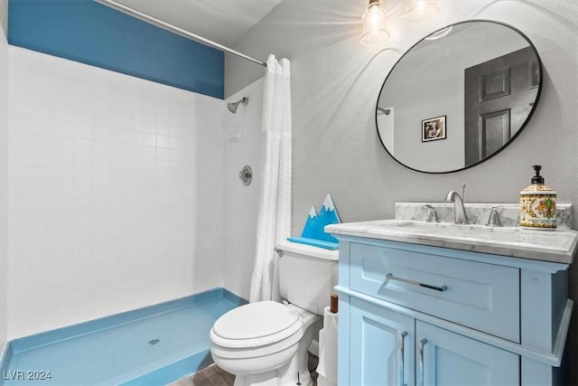 bathroom featuring a shower stall, toilet, and vanity