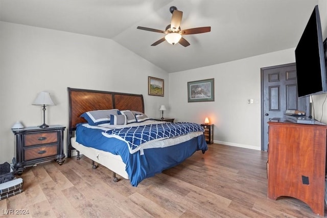 bedroom with a ceiling fan, vaulted ceiling, wood finished floors, and baseboards