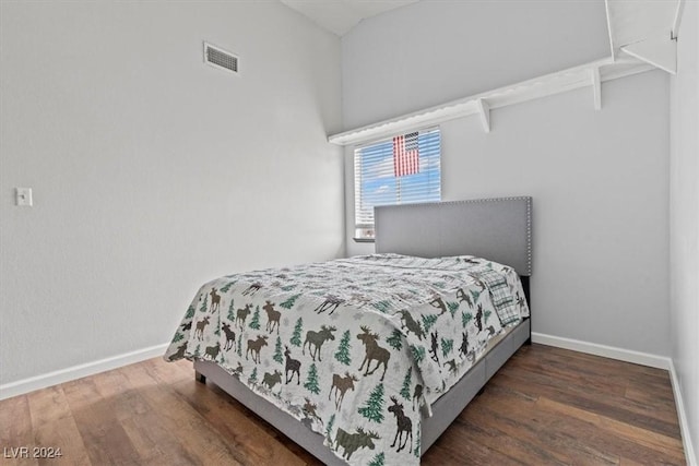 bedroom with wood finished floors, visible vents, and baseboards