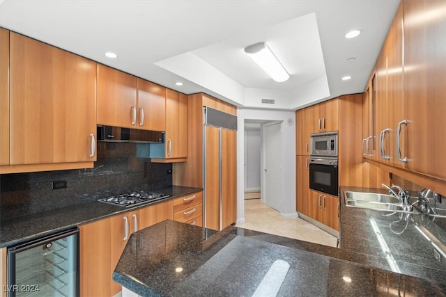 kitchen featuring built in appliances, backsplash, wine cooler, light tile patterned floors, and sink