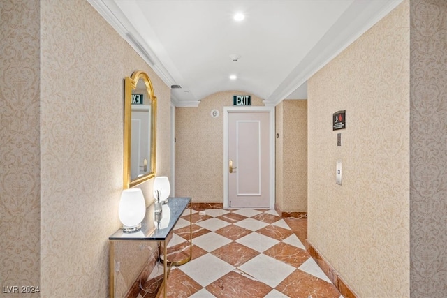 hall with ornamental molding and light tile patterned floors