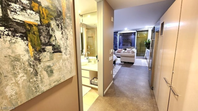 corridor featuring sink and tile patterned floors