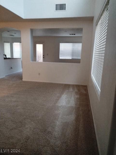 unfurnished room featuring plenty of natural light and carpet