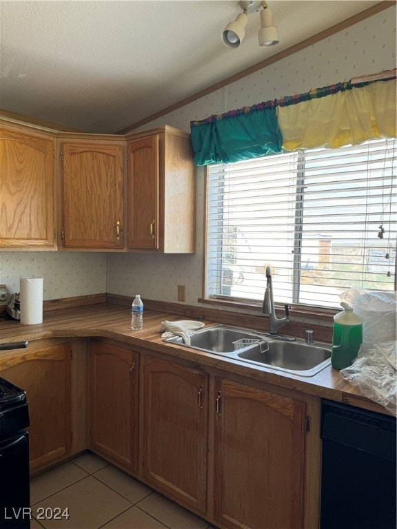 kitchen featuring light tile patterned flooring, sink, crown molding, black appliances, and lofted ceiling