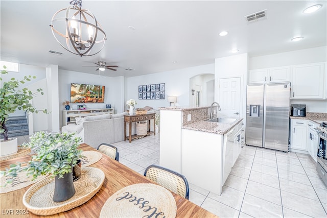 kitchen with white cabinets, sink, stainless steel appliances, and hanging light fixtures