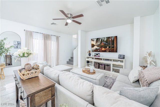 living room featuring light tile patterned floors and ceiling fan