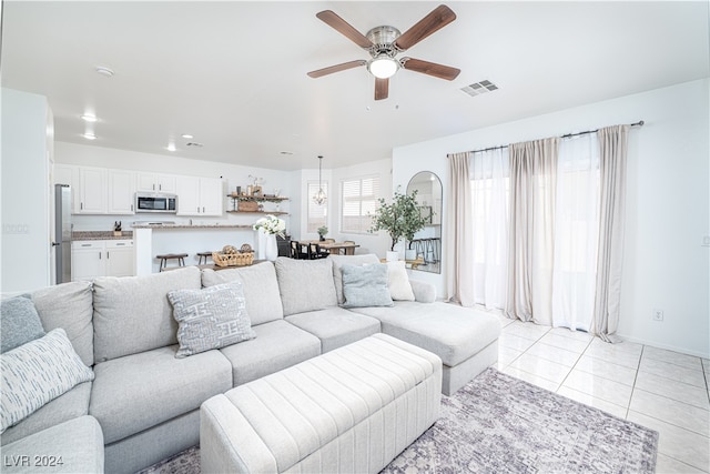 living room featuring light tile patterned floors and ceiling fan