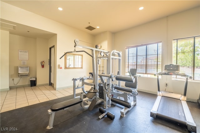 exercise area with heating unit and light tile patterned flooring