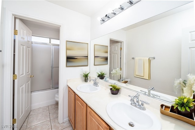 full bathroom with tile patterned flooring, vanity, toilet, and enclosed tub / shower combo