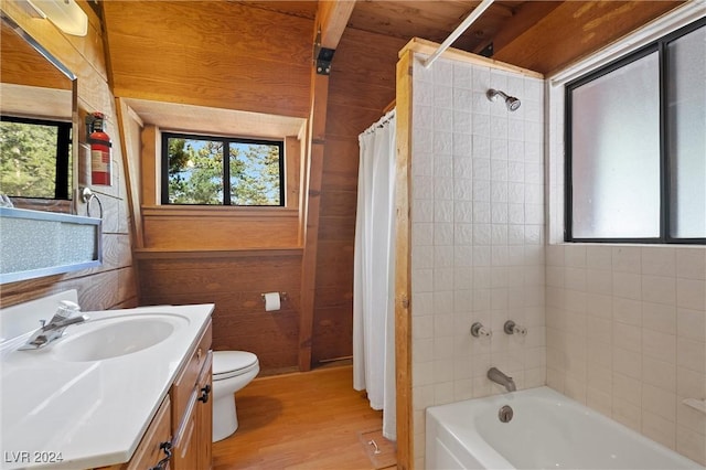 full bath featuring shower / bath combination with curtain, wood finished floors, vanity, toilet, and wooden walls