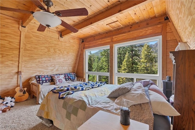 bedroom featuring multiple windows, carpet, wooden walls, and ceiling fan