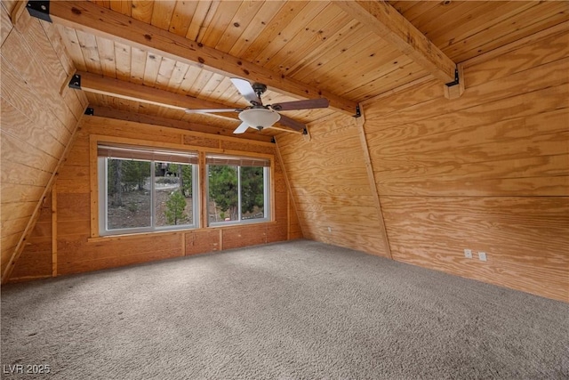 carpeted spare room featuring wooden walls, beam ceiling, ceiling fan, and wood ceiling