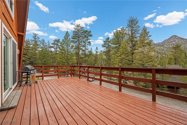 wooden deck with a mountain view and grilling area