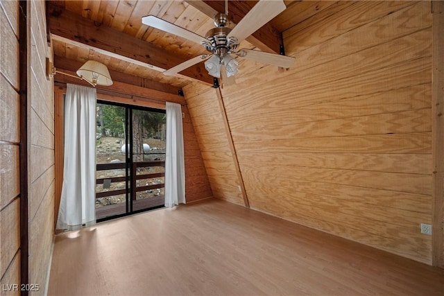 unfurnished room with ceiling fan, wood walls, wood finished floors, wooden ceiling, and beamed ceiling