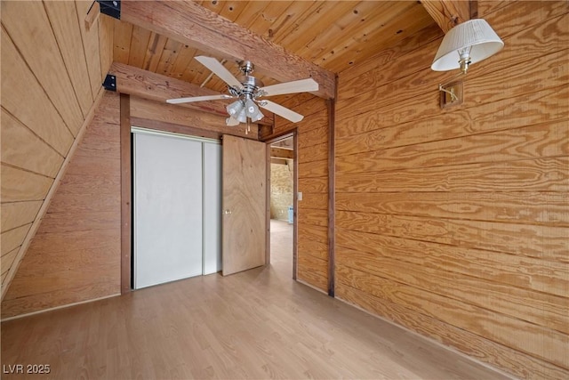 bonus room featuring wooden walls, ceiling fan, beam ceiling, and wood finished floors