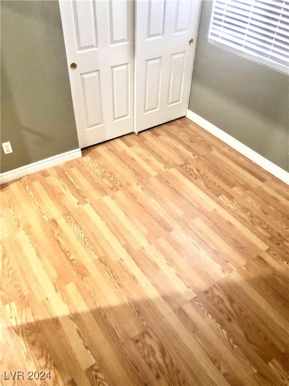 unfurnished bedroom with a closet and light wood-type flooring