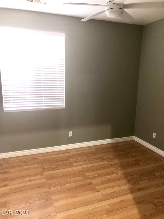 empty room with ceiling fan and light hardwood / wood-style floors