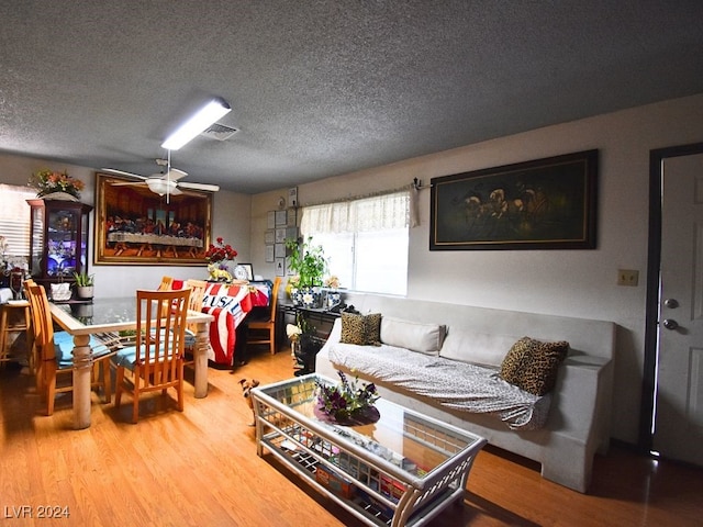 living room featuring a textured ceiling, ceiling fan, and hardwood / wood-style flooring