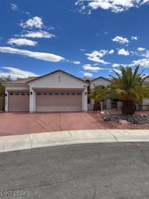 view of front of house featuring a garage, driveway, fence, and stucco siding