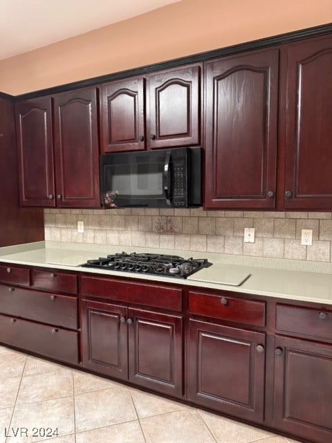 kitchen with stainless steel gas stovetop, tasteful backsplash, and light tile patterned flooring