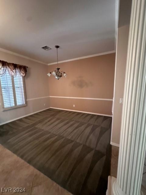 empty room with crown molding and tile patterned floors