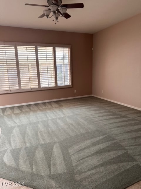 carpeted spare room featuring ceiling fan